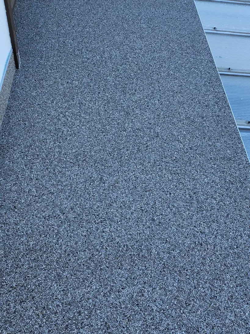 Nachher: Verwitterte Betonplatte vor dem Fenster – jetzt blaugrauer Steinteppich