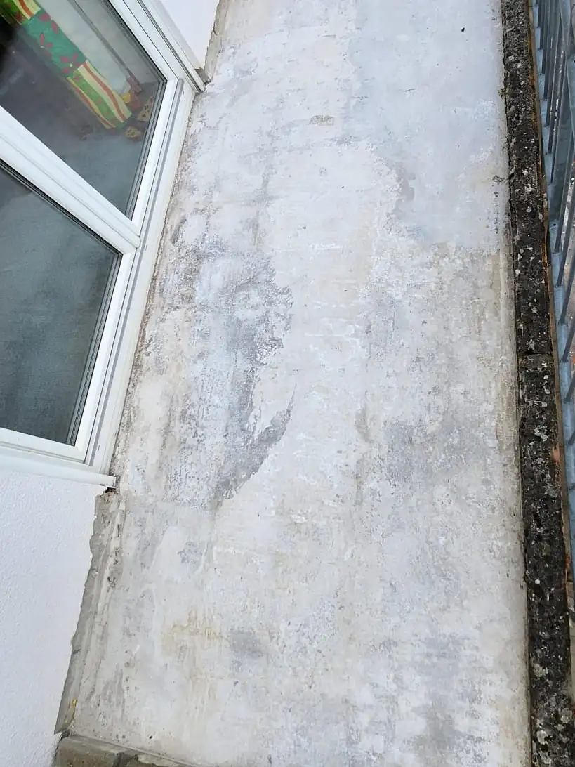 Vorher: Verwitterte Betonplatte vor dem Fenster – jetzt blaugrauer Steinteppich