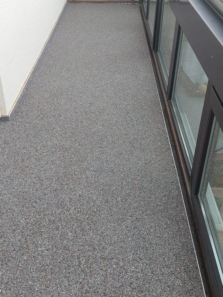 Nachher: Gefliester Balkon mit Glasgeländer – Steinteppich in Anthrazit-Mix