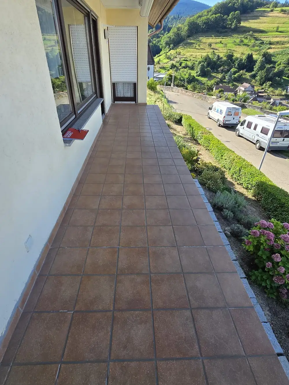 Vorher: Langer Balkon mit Blick in die Reben – alte Fliesen überarbeitet, abgedichtet und mit grauem Steinteppich belegt