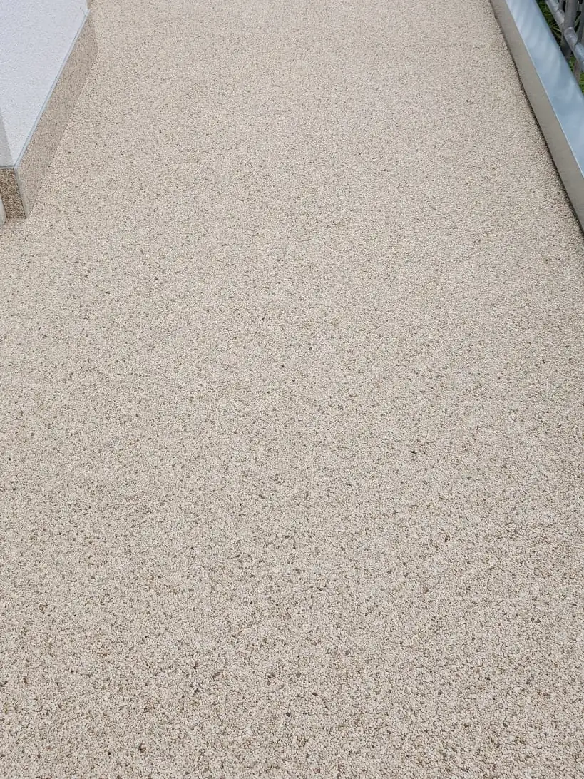 Nachher: Großformatige Platten überarbeitet – Steinteppich in Sandbeige