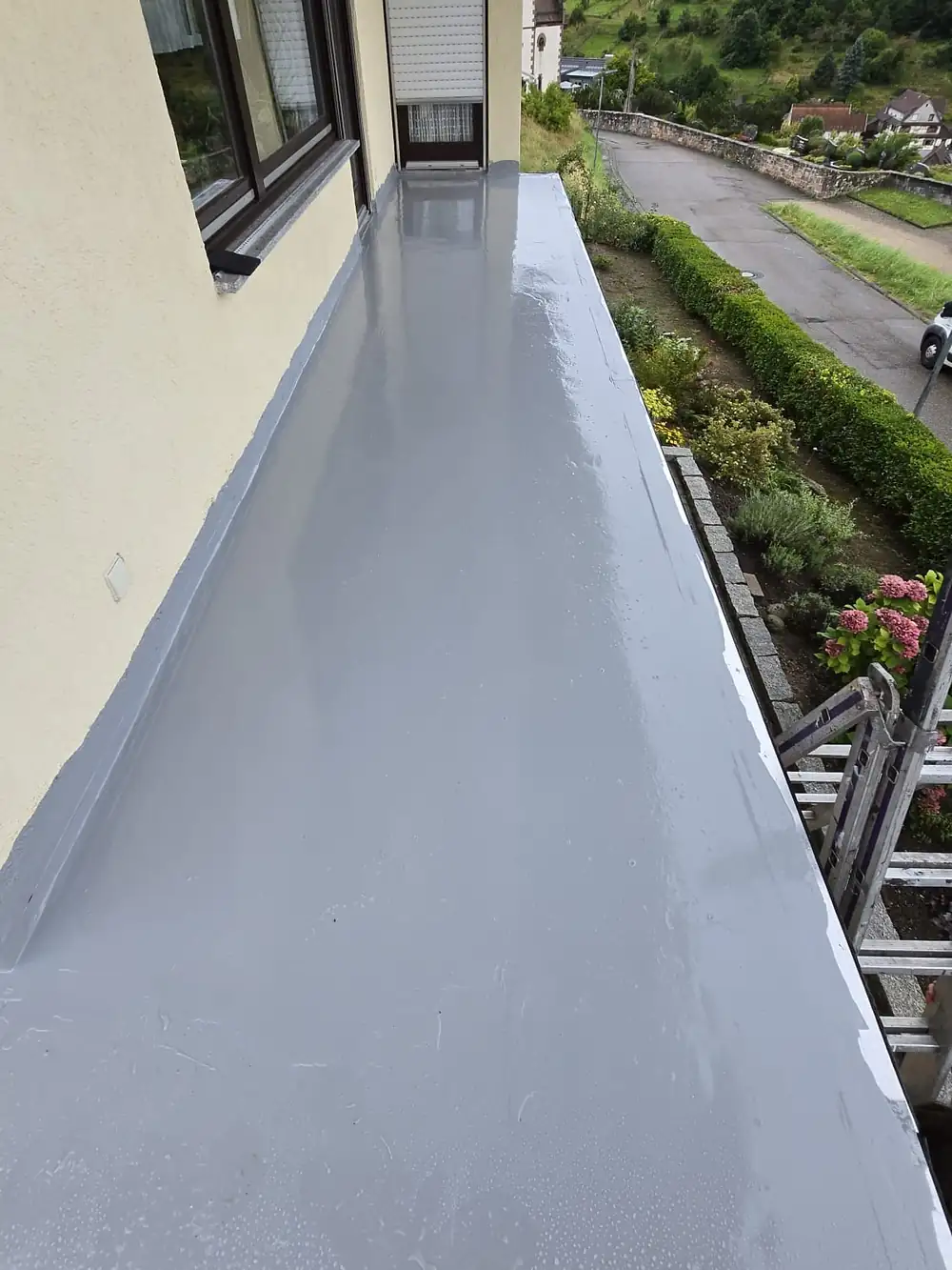 Nachher: Derselbe Balkon im Zwischenschritt: vollflächige Polyurea-Abdichtung (PUA), darauf folgt der Steinteppich