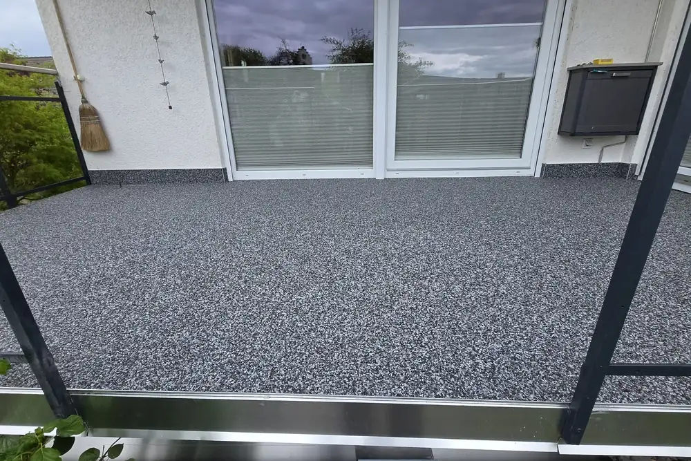 Balkon mit anthrazitfarbenem Steinteppich und Stahlpfosten