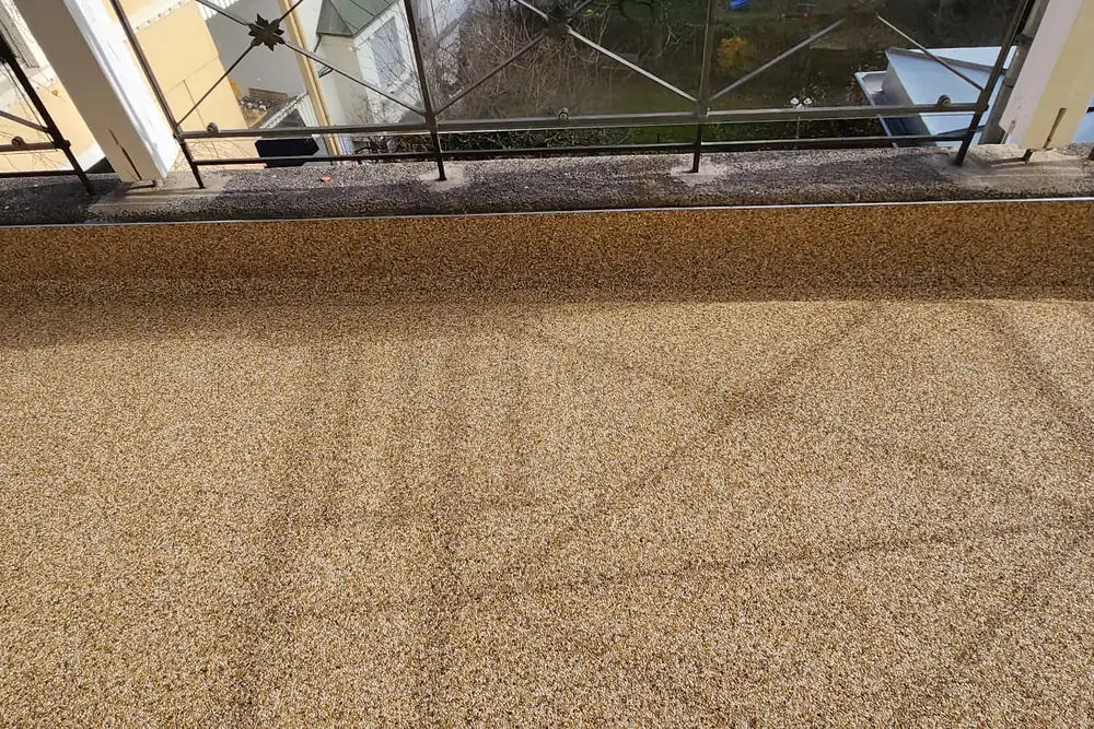 Balkon mit Steinteppich in Ocker, Aufkantung sauber mitbeschichtet