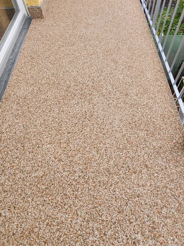 Balkon mit sandfarbenem Steinteppich