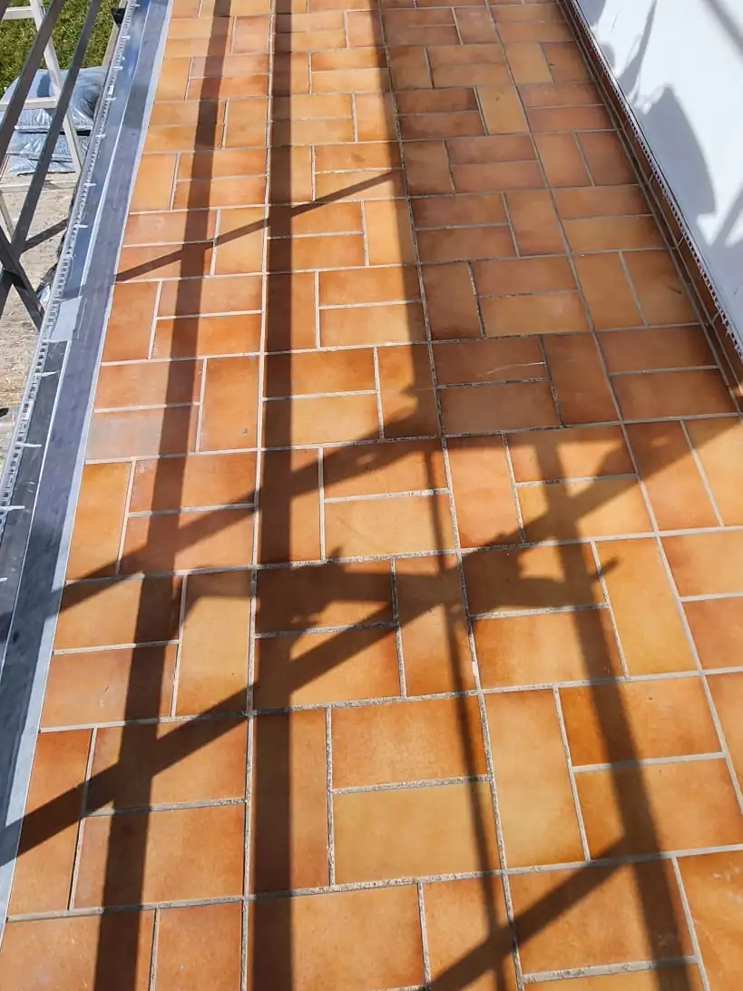 Vorher: Terracotta-Balkon in Südlage – dunkelgrauer Steinteppich