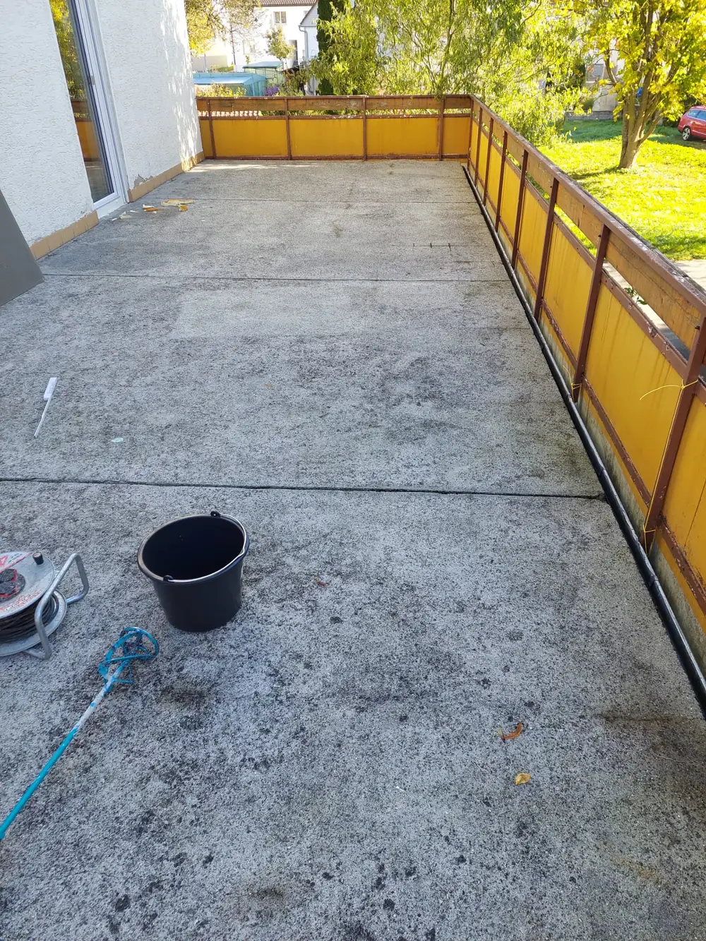 Vorher: Großflächige Dachterrasse: Betonplatten abgedichtet, darauf grauer Steinteppich