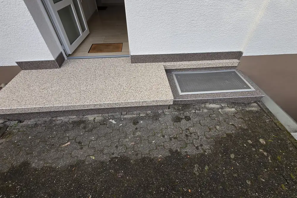 Nachher: Eingang mit Lichtschacht – Fläche und Stufe in Beige