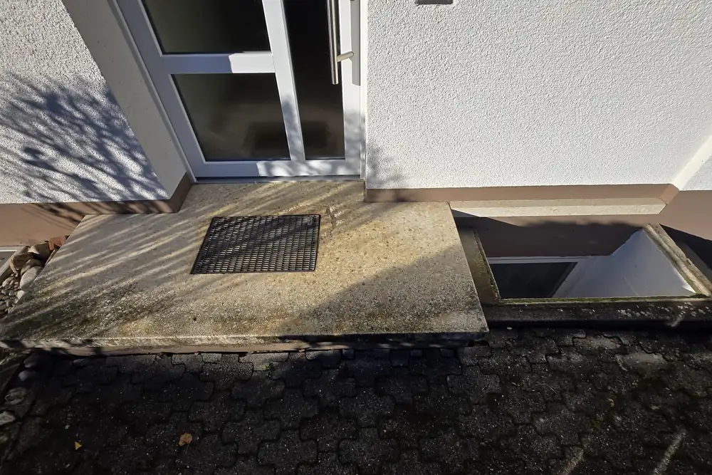Vorher: Eingang mit Lichtschacht – Fläche und Stufe in Beige