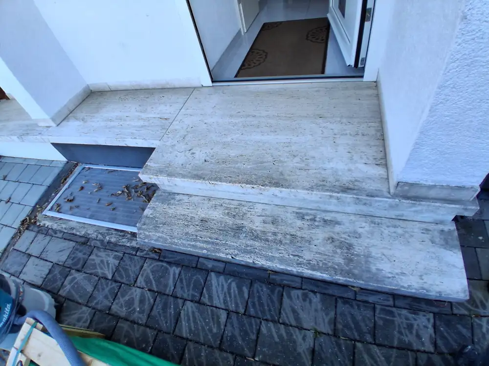 Vorher: Eingangspodest aus Beton – mit dunklem Steinteppich und Sockelkante