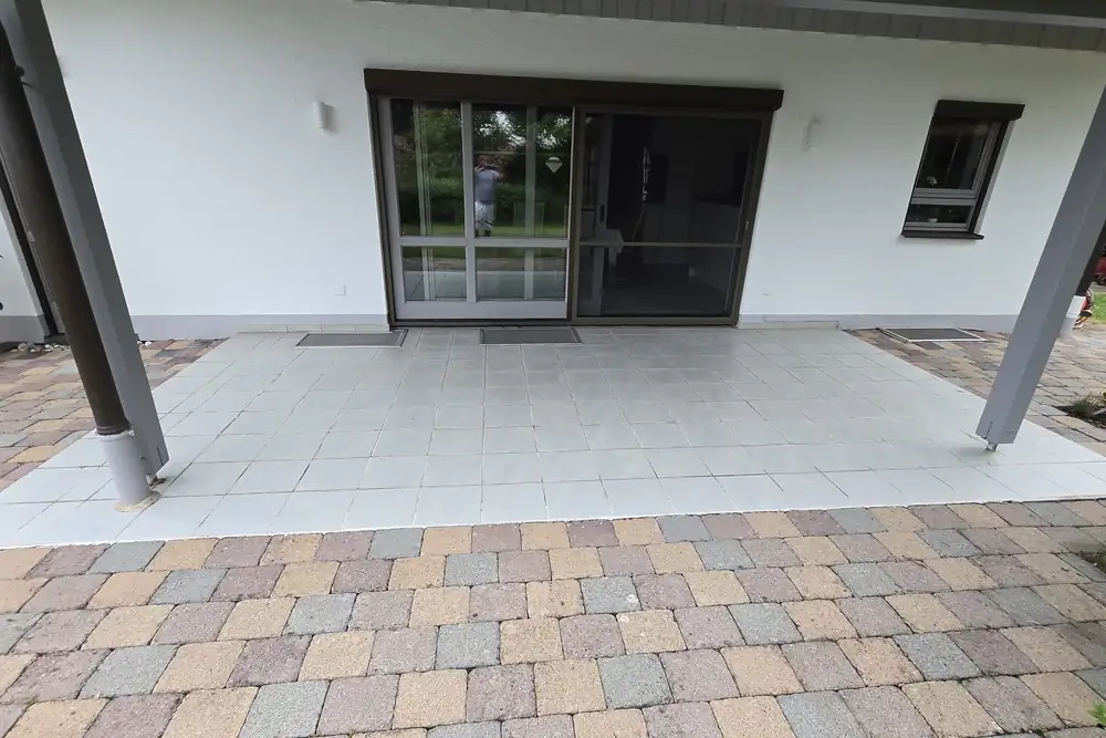 Vorher: Überdachte Terrasse: helle Fliesen raus, Steinteppich in Sandbeige rein